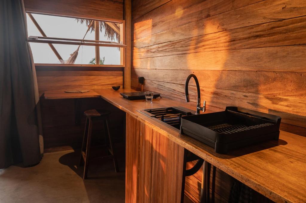 Sunlight falling on a wooden kitchenette with a black sink