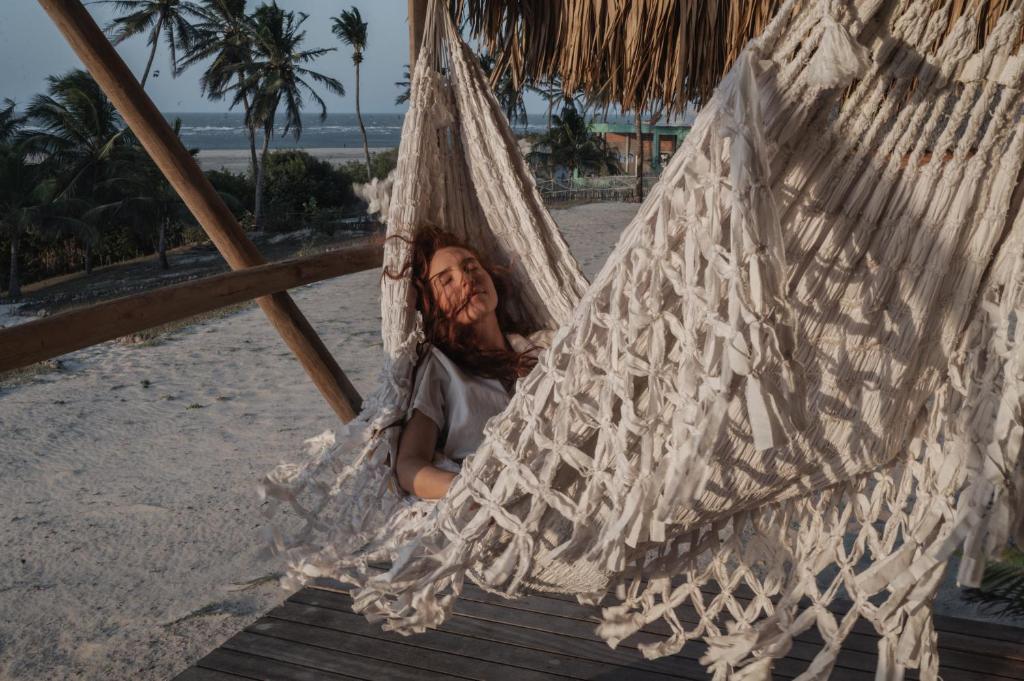 Relaxing in a handwoven hammock overlooking palms and the sea